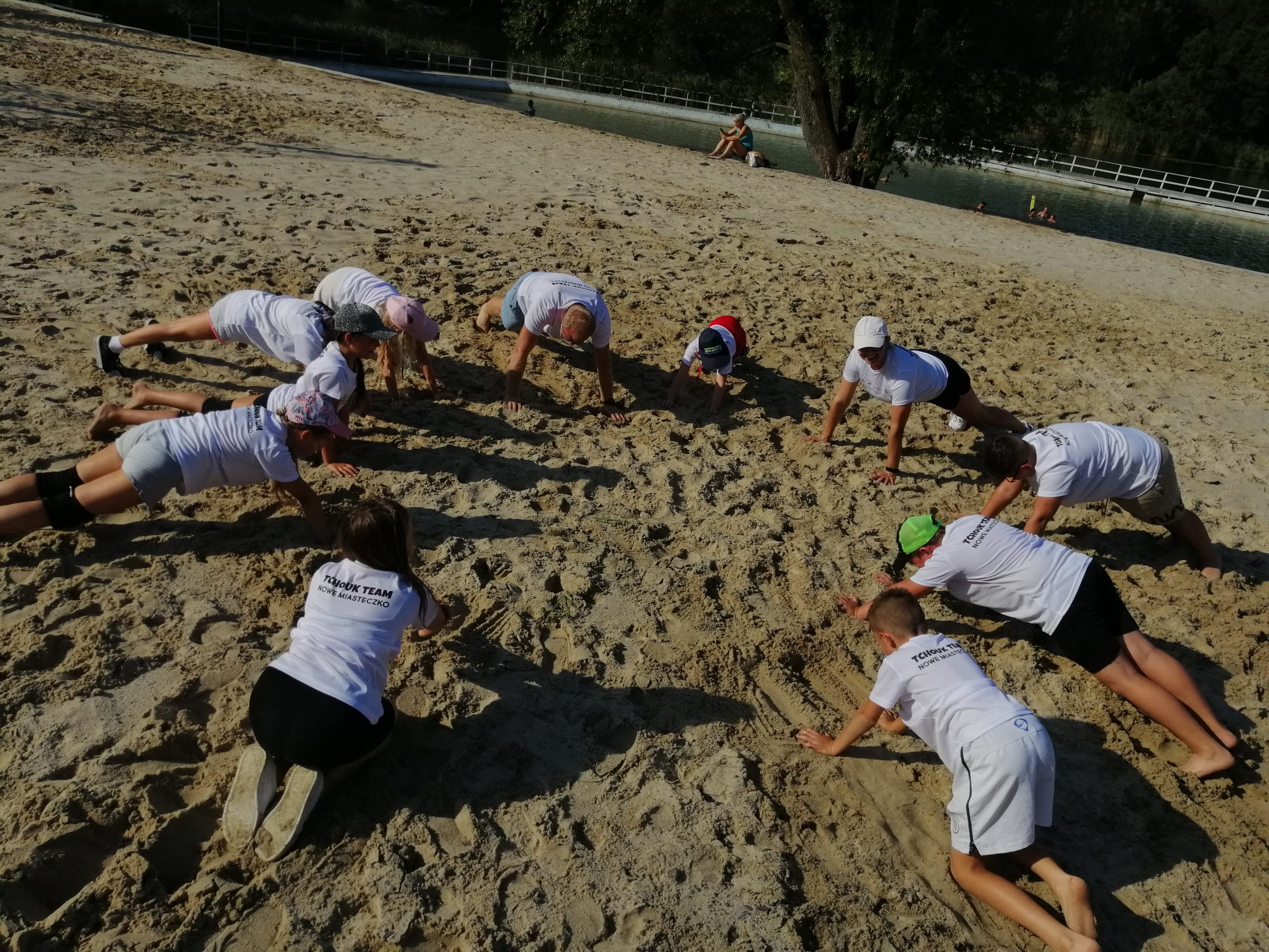 Zdjęcie przedstawia rozgrzewkę zespołu tchouk team - deska wysoka w wykonaniu dzieci